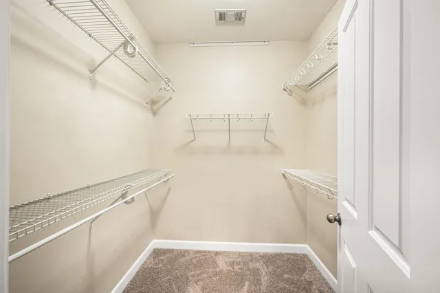 an empty room with ceiling fan and windows
