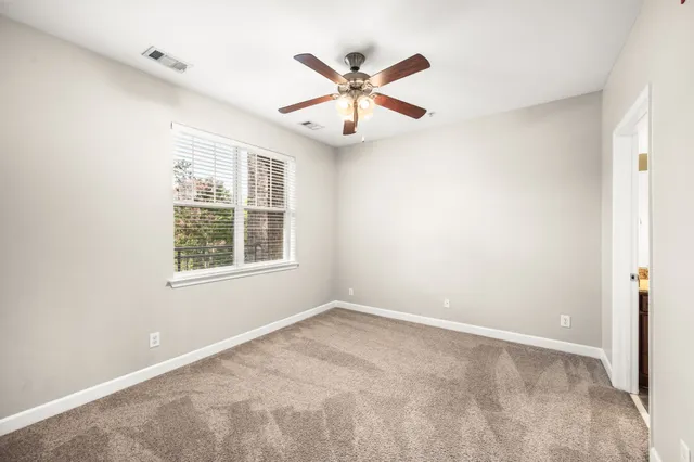 an empty room with closet and a ceiling fan