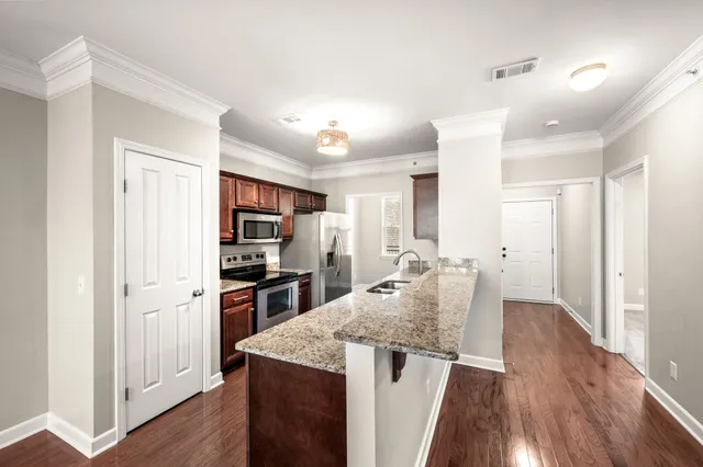a kitchen with kitchen island a counter top space a sink stainless steel appliances and cabinets