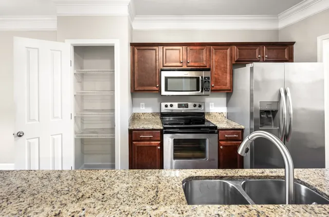 a kitchen with stainless steel appliances granite countertop a refrigerator sink and stove