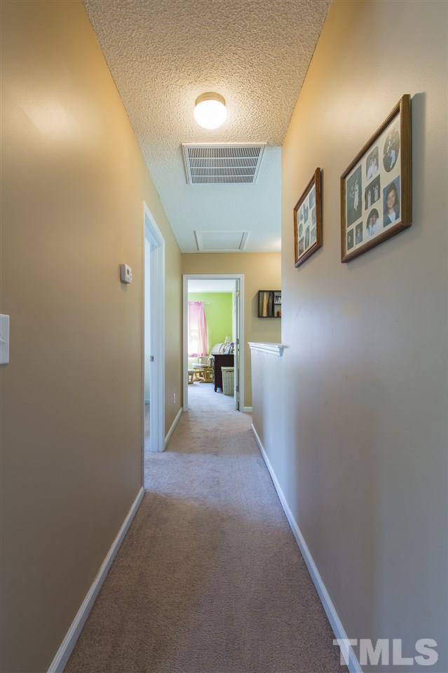 5302 Interlock Drive Raleigh, NC 27610 - Photo 18 of 19 a view of a hallway with wooden floor and a living room