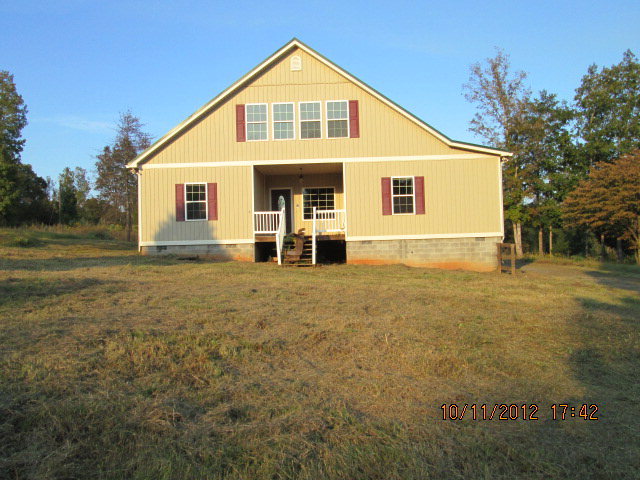 a view of a yard in front of a house with large trees