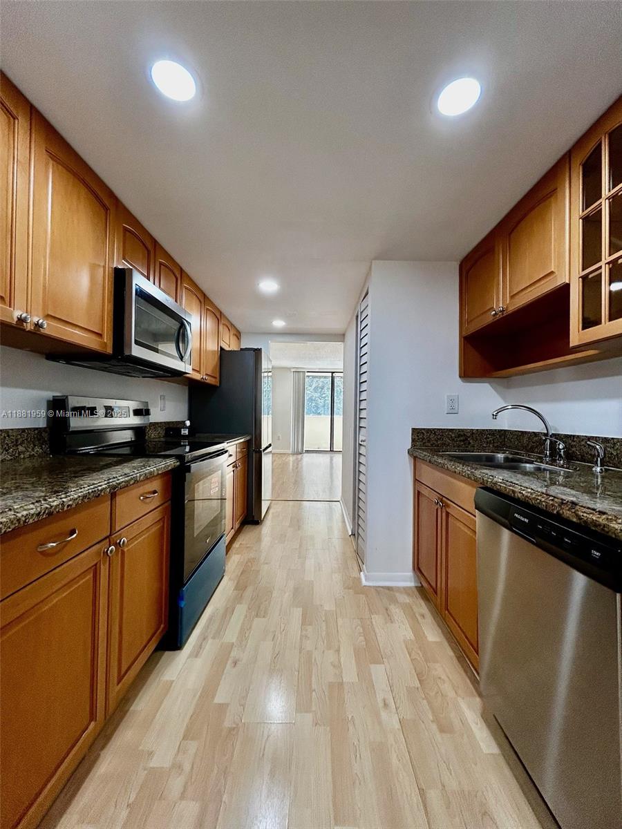 a large kitchen with stainless steel appliances granite countertop a stove and a sink