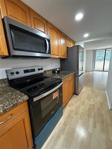 a kitchen with stainless steel appliances granite countertop a stove a sink and a microwave