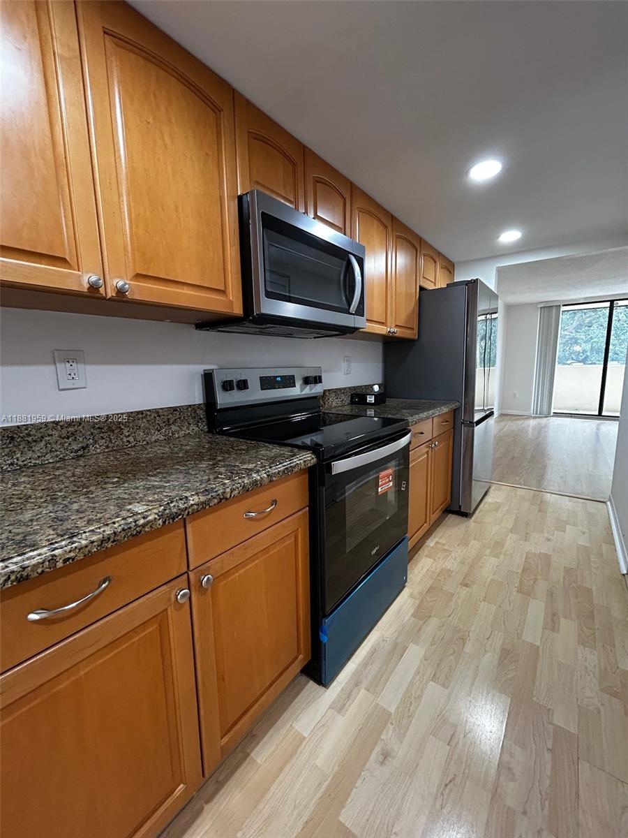 7451 Northwest 16th Street, Unit 304 Plantation, FL 33313 - Photo 12 of 59 a kitchen with stainless steel appliances granite countertop a stove a sink and a microwave