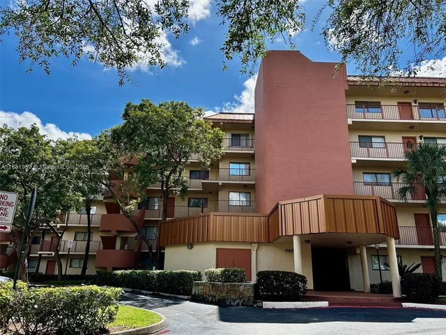 a view of a patio with table and chairs under an umbrella