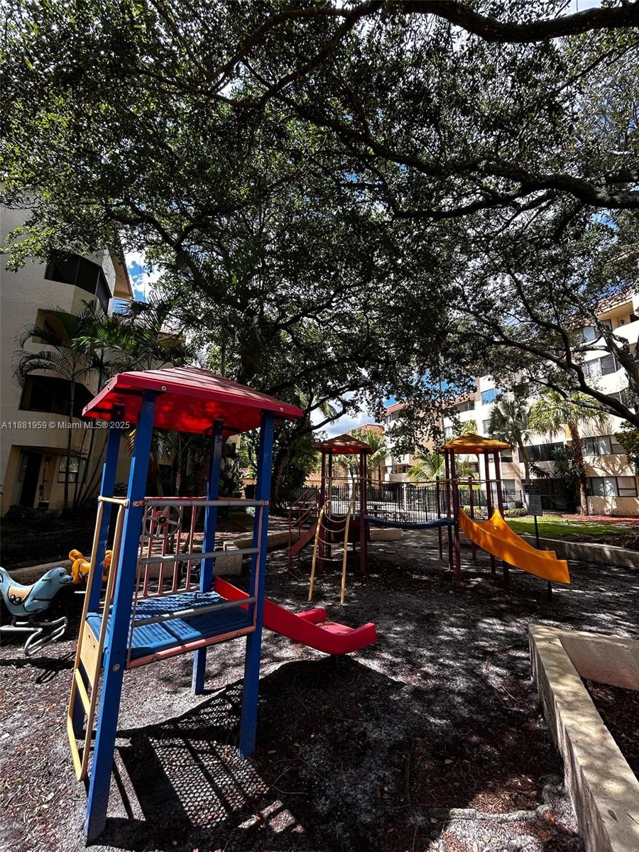 7451 Northwest 16th Street, Unit 304 Plantation, FL 33313 - Photo 55 of 59 a view of a patio with table and chairs under an umbrella
