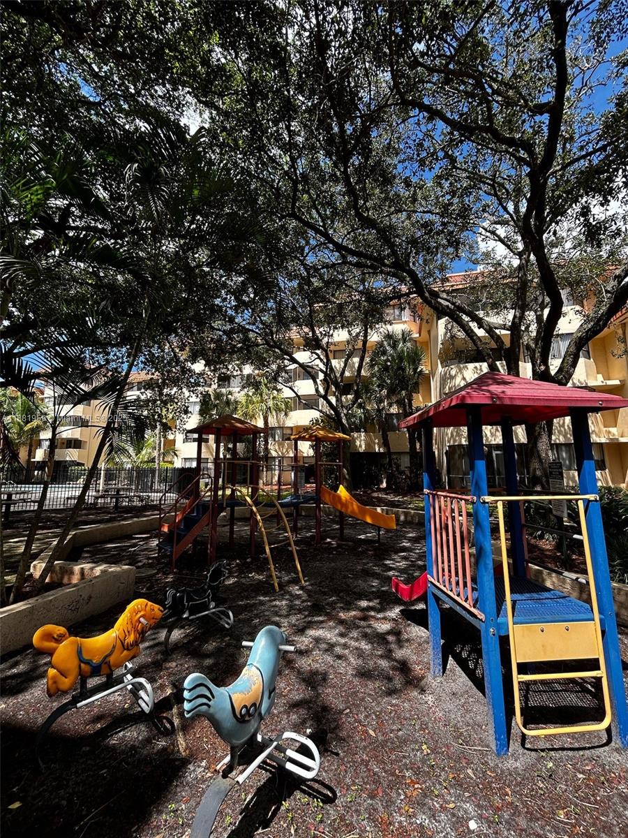7451 Northwest 16th Street, Unit 304 Plantation, FL 33313 - Photo 57 of 59 a view of a patio with table and chairs under an umbrella
