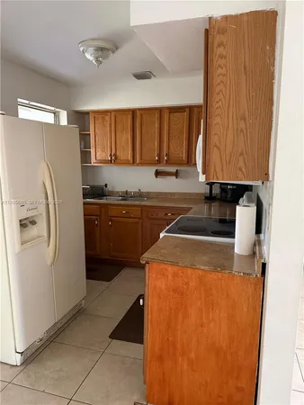 a kitchen with a refrigerator sink and cabinets