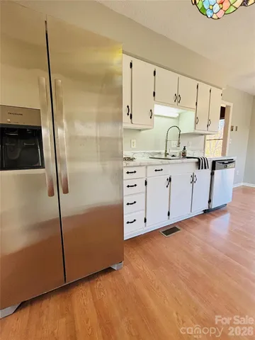 a view of kitchen island with stainless steel appliances granite countertop sink stove and wooden cabinets