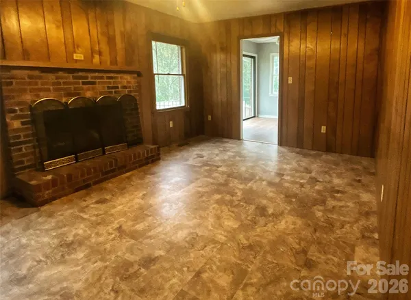 a view of a livingroom with a fireplace and window