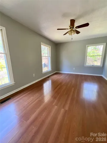 a spacious bedroom with a bed and a flat screen television