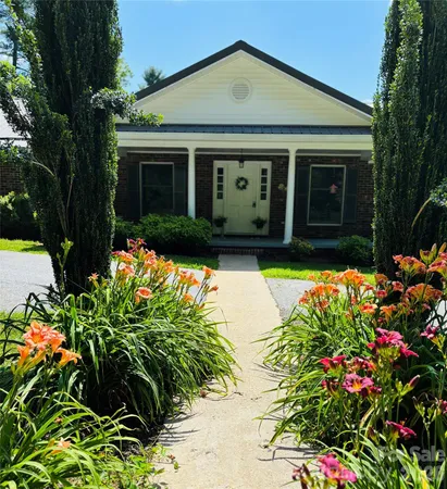 a front view of a house with a yard and fountain