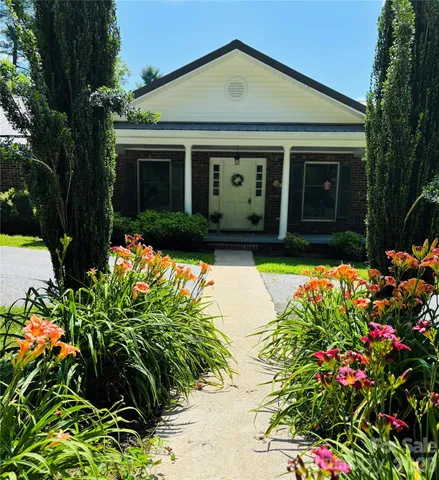 a front view of a house with a yard and fountain