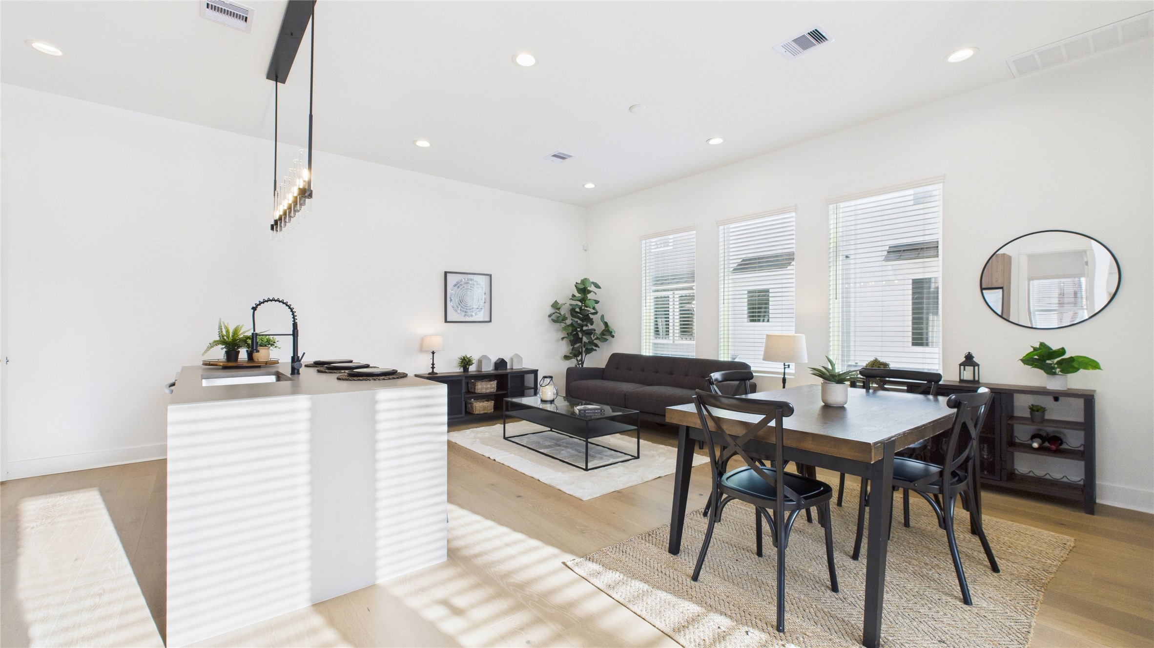 2426 Freeman Street Houston, TX 77009 - Photo 12 of 47 The welcoming second-floor open-concept living area seamlessly combines the living room, dining room, and kitchen, filled with natural light and enhanced by modern finishes and engineered hardwood flooring throughout, creating a bright and inviting space ideal for everyday living and entertaining.