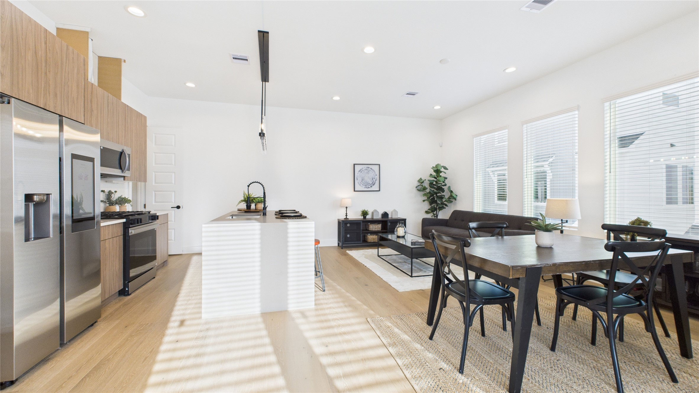2426 Freeman Street Houston, TX 77009 - Photo 13 of 47 The welcoming second-floor open-concept living area seamlessly combines the living room, dining room, and kitchen, filled with natural light and enhanced by modern finishes and engineered hardwood flooring throughout, creating a bright and inviting space ideal for everyday living and entertaining.