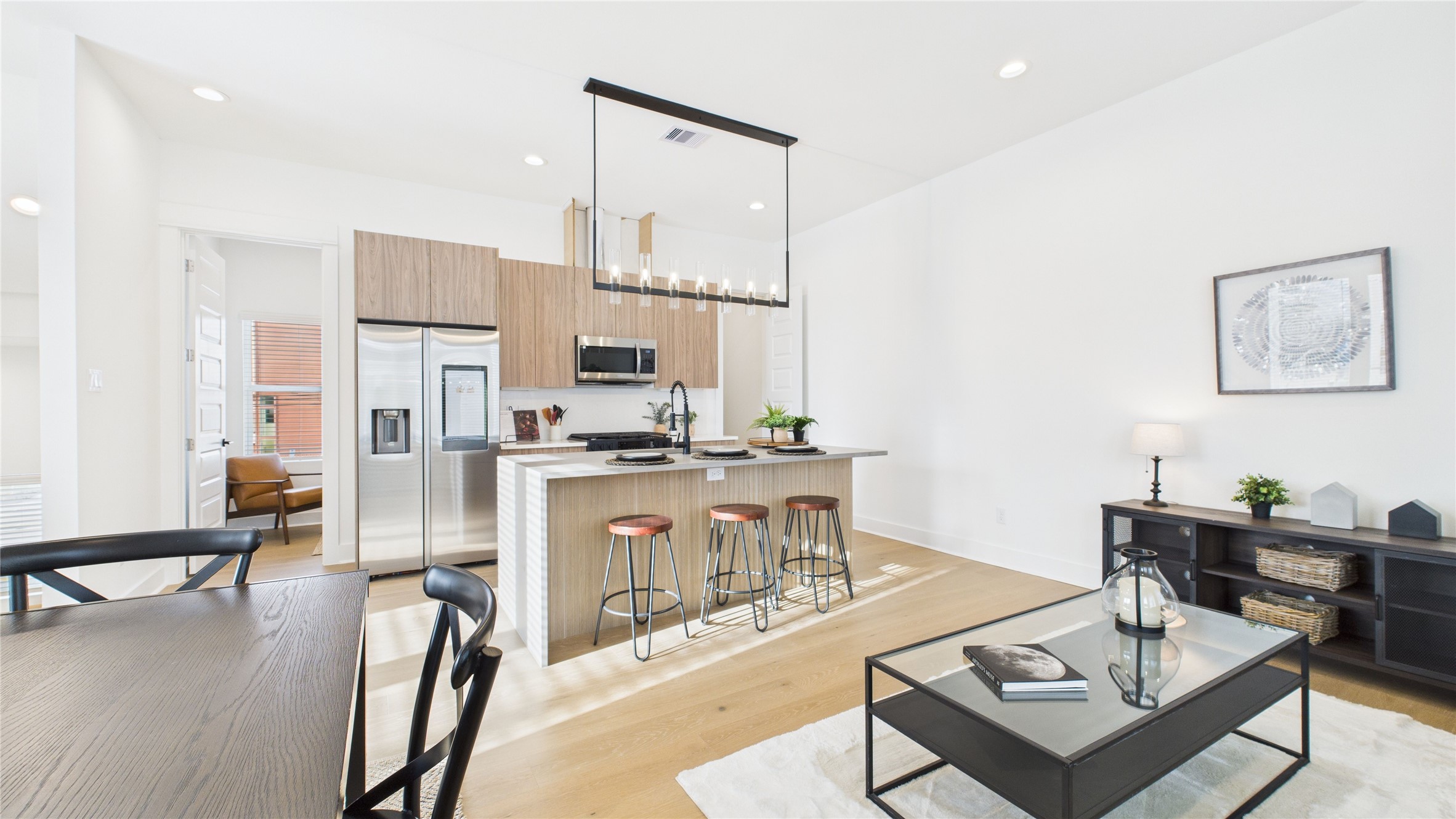 2426 Freeman Street Houston, TX 77009 - Photo 16 of 47 The welcoming second-floor open-concept living area seamlessly combines the living room, dining room, and kitchen, filled with natural light and enhanced by modern finishes and engineered hardwood flooring throughout, creating a bright and inviting space ideal for everyday living and entertaining.
