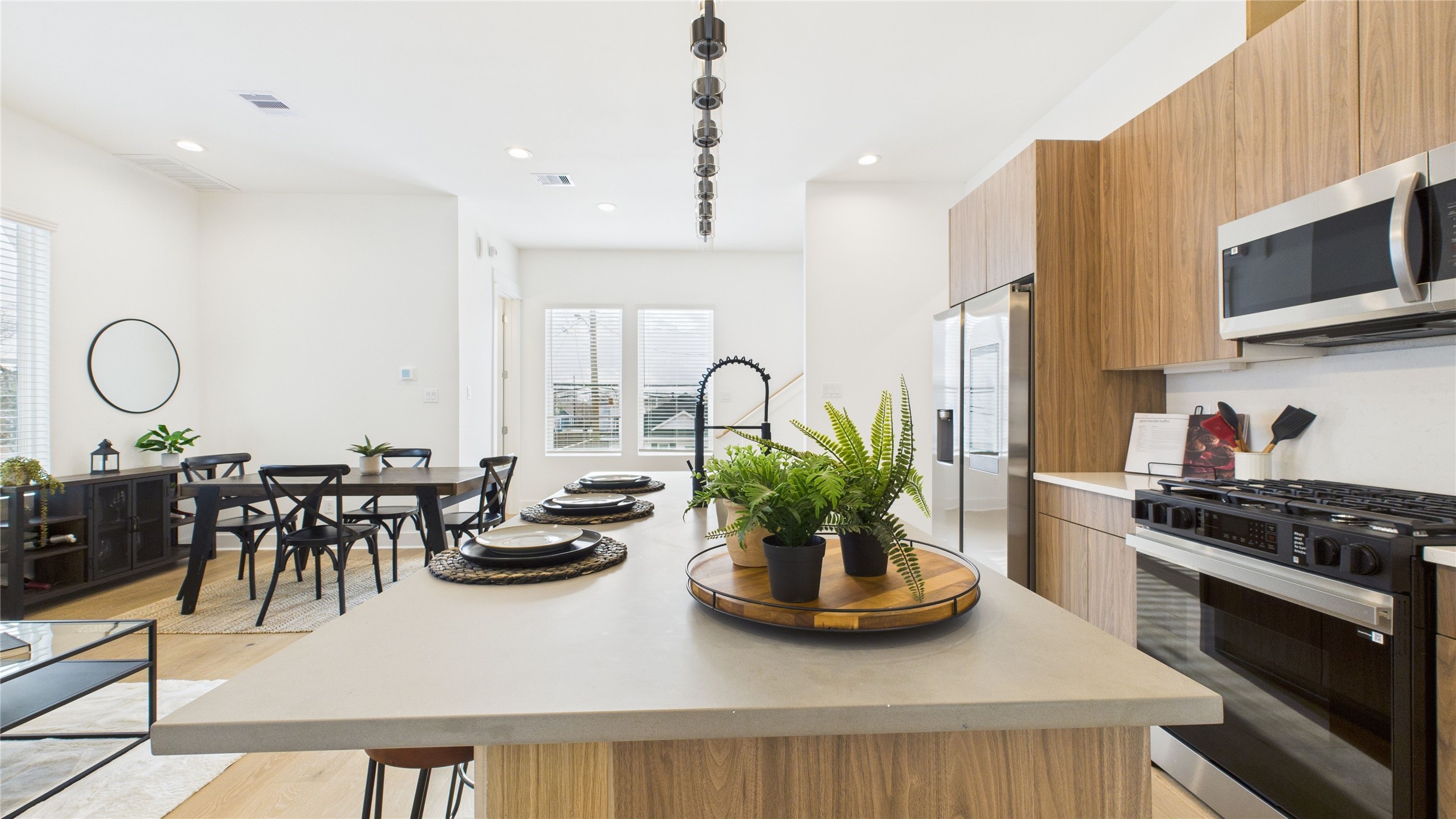 2426 Freeman Street Houston, TX 77009 - Photo 19 of 47 The heart of the second-floor open-concept living, dining, and kitchen, this spacious kitchen island features sleek modern finishes, including a one-sided cascade quartz countertop, a farmhouse sink, and stylish pendant lighting, with a built-in seating area perfect for casual breakfasts or chatting with family and friends.