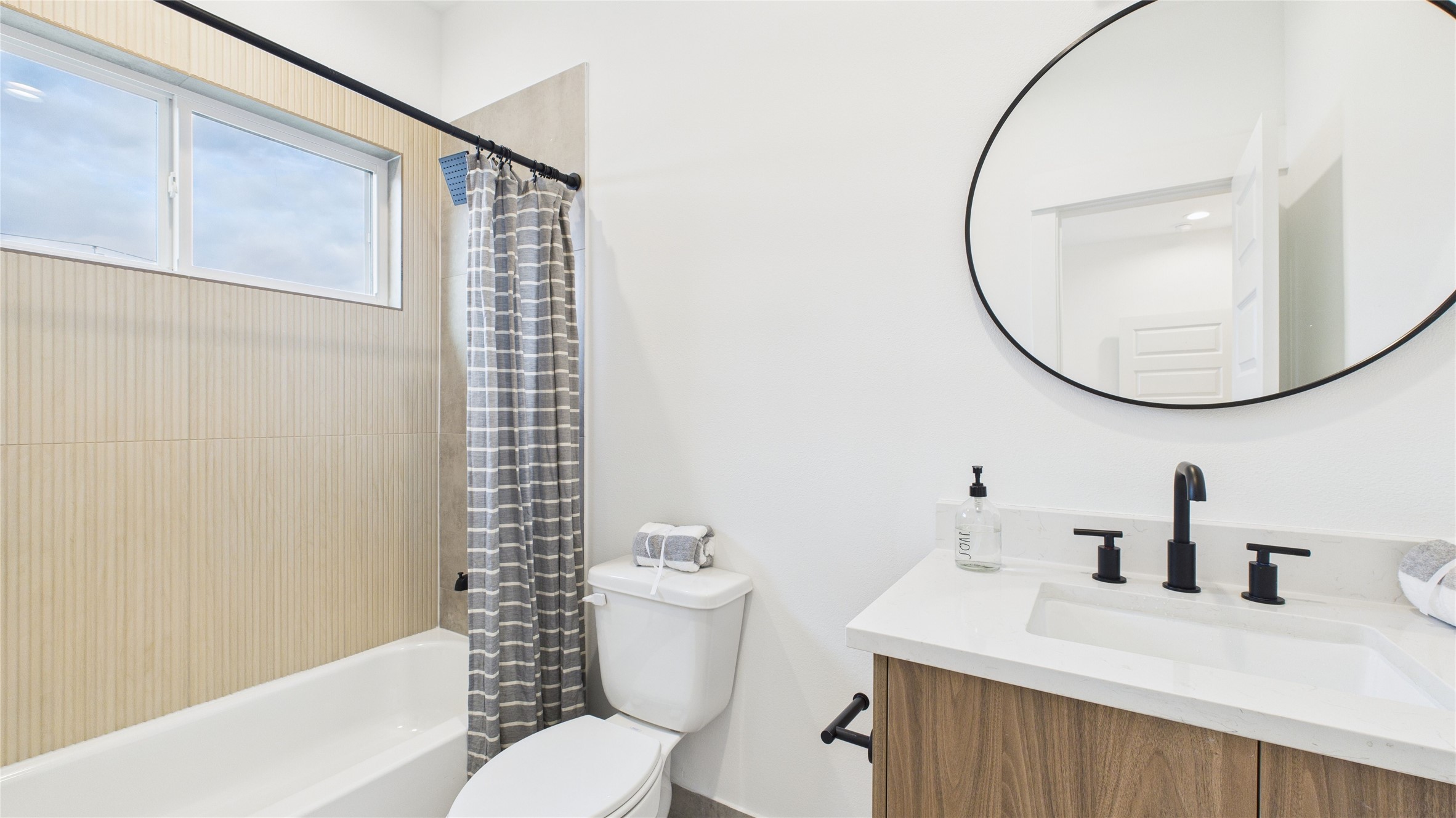 2426 Freeman Street Houston, TX 77009 - Photo 36 of 47 The ensuite bathroom of the second secondary bedroom features a tub/shower combo and a sleek quartz vanity, combining functionality with modern elegance for a comfortable and stylish space.
