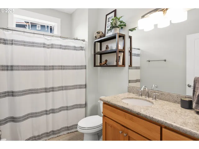 a bathroom with a granite countertop sink a toilet and a mirror