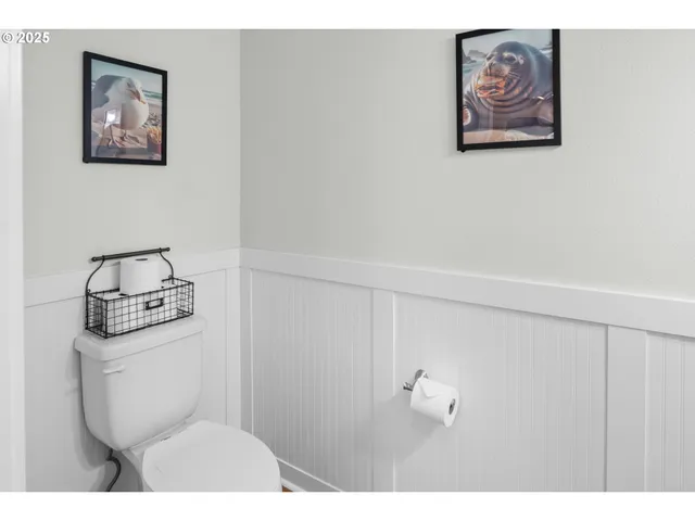 a bathroom with a toilet and a picture on the wall