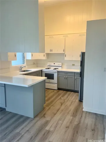 a kitchen with stainless steel appliances a stove a sink and white cabinets