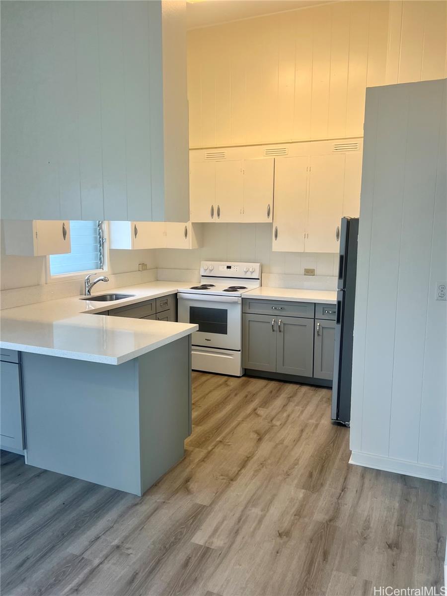 a kitchen with stainless steel appliances a stove a sink and white cabinets