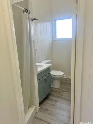 a bathroom with a sink a toilet a shower and a window