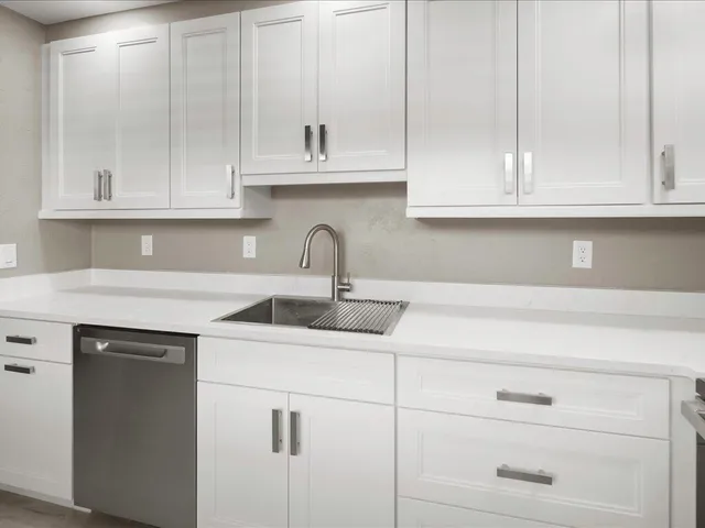 a kitchen with white cabinets and a sink