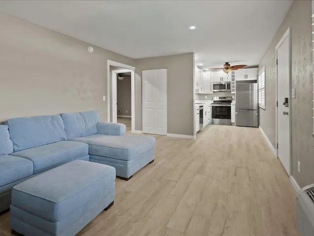 a living room with furniture and kitchen view