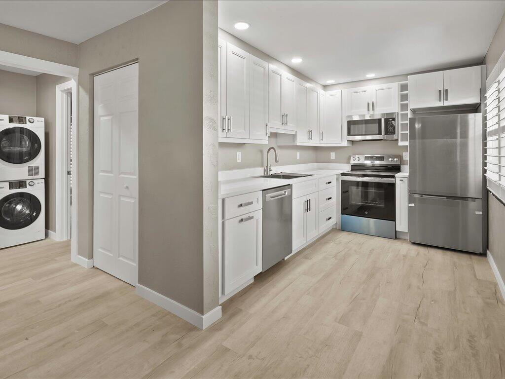 850 Palm Street, Unit E2 Marco Island, FL 34145 - Photo 9 of 23 a large kitchen with cabinets stainless steel appliances and wooden floor