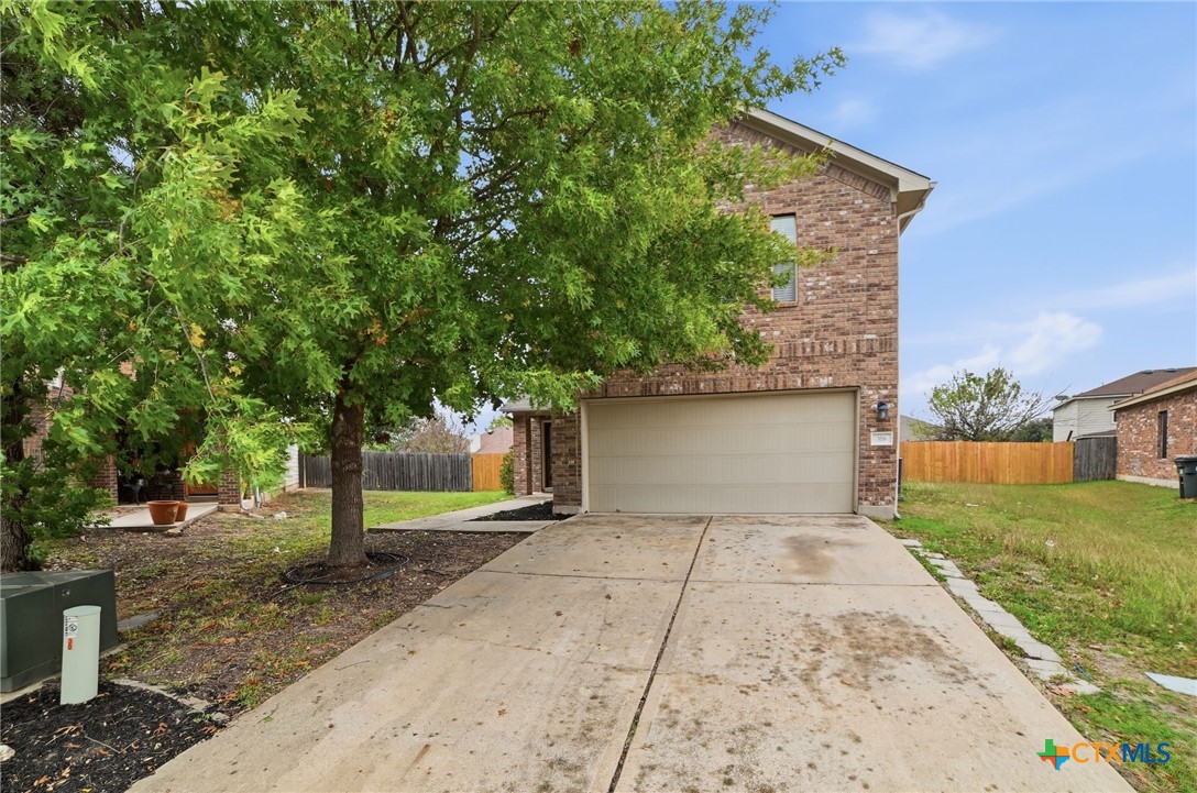 316 Housefinch Loop Leander, TX 78641 - Photo 8 of 37 Front driveway, 2-car garage, view with mature trees and great curb appeal.