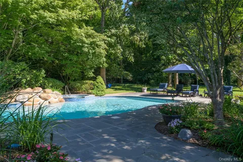 a patio with wooden floor a yard a table and chairs