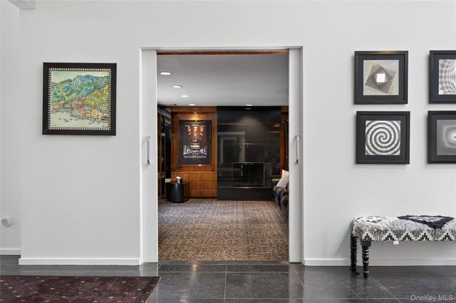 a view of a hallway with wooden floor and furniture