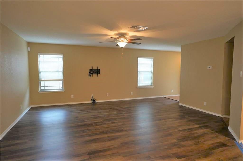 201 Edwin Kyle, TX 78640 - Photo 6 of 21 Expansive room featuring wood-finish flooring, neutral wall tones, and white baseboards