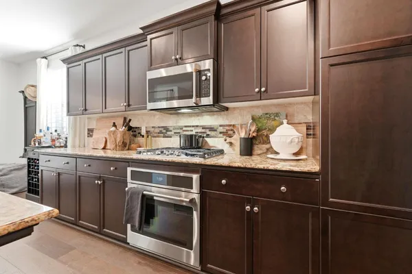 a living room with stainless steel appliances kitchen island granite countertop furniture and a dining table