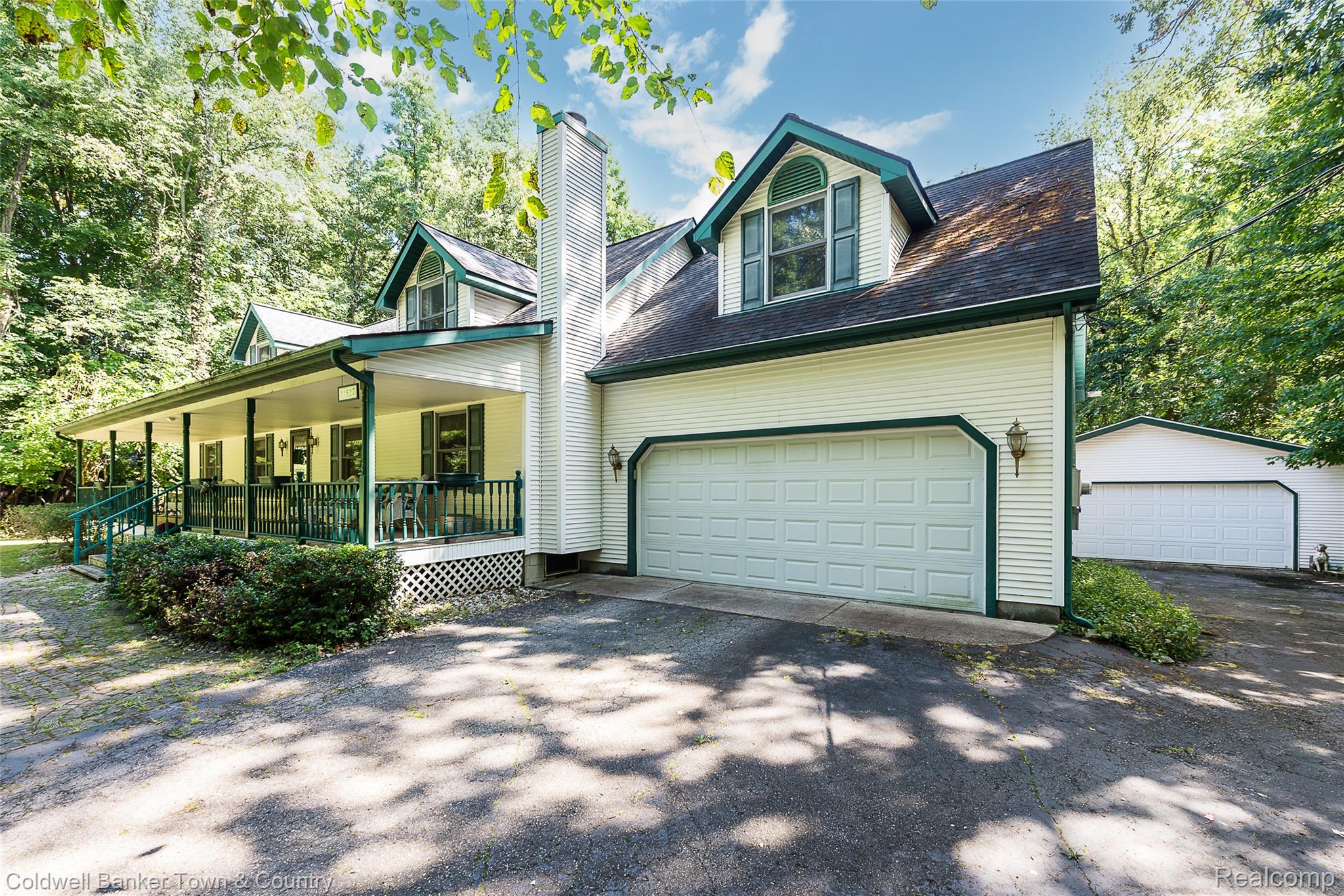 11527 Mcgregor Road Pinckney, MI 48169 - Photo 2 of 26 View of front facade with covered porch, a garage, a chimney, and driveway