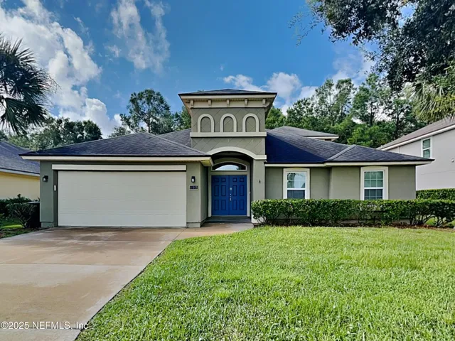 a front view of a house with a garden and trees