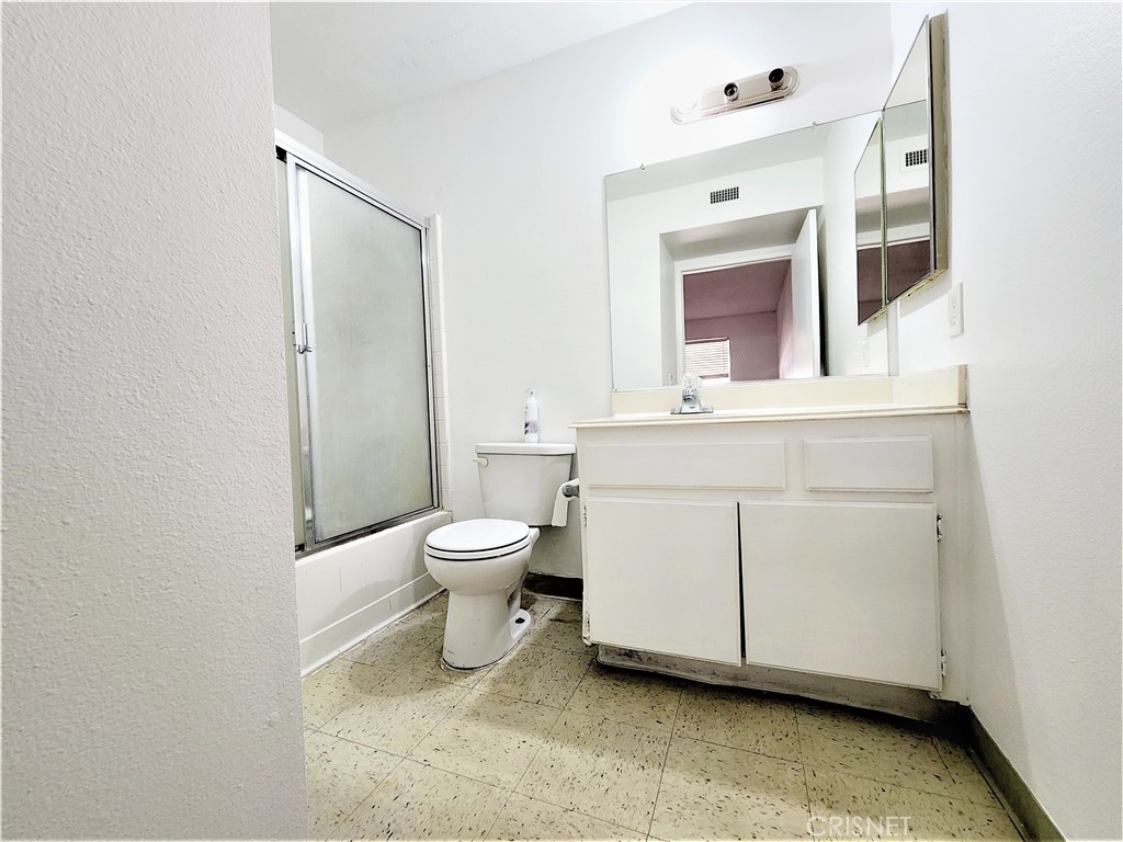 12601 Van Nuys Boulevard, Unit 138 Pacoima, CA 91331 - Photo 14 of 19 a spacious bathroom with a toilet sink and mirror