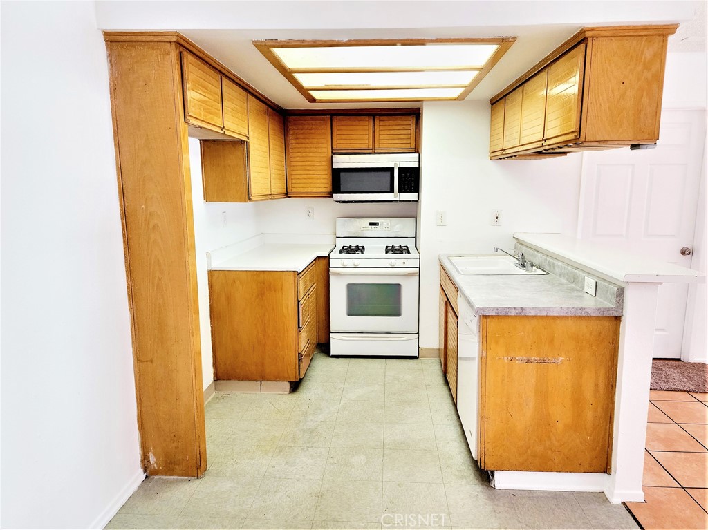 12601 Van Nuys Boulevard, Unit 138 Pacoima, CA 91331 - Photo 6 of 19 a kitchen with stainless steel appliances a stove a sink and a microwave