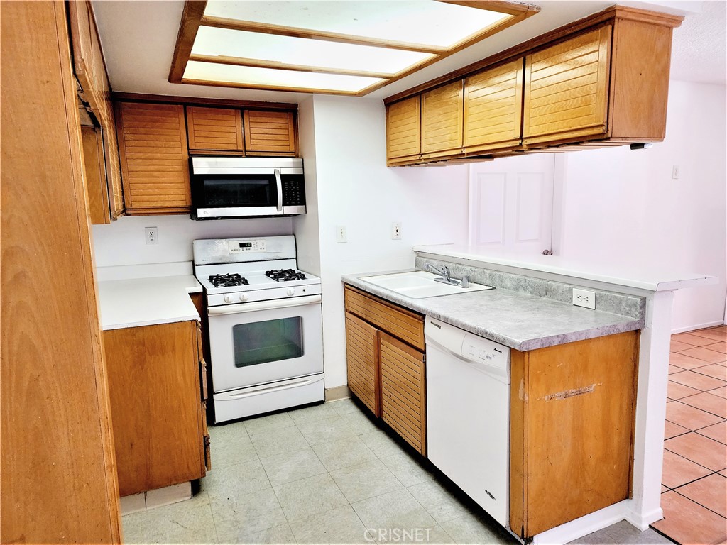 12601 Van Nuys Boulevard, Unit 138 Pacoima, CA 91331 - Photo 7 of 19 a kitchen with stainless steel appliances granite countertop a stove and a microwave