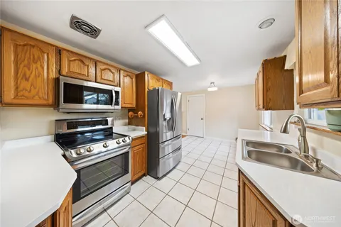 a kitchen with stainless steel appliances a stove sink microwave and cabinets