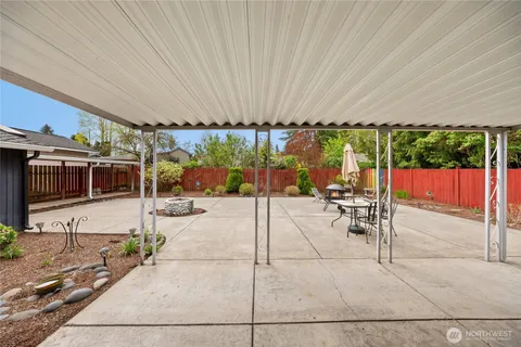 a view of a patio with table and chairs potted plants with the view of the back