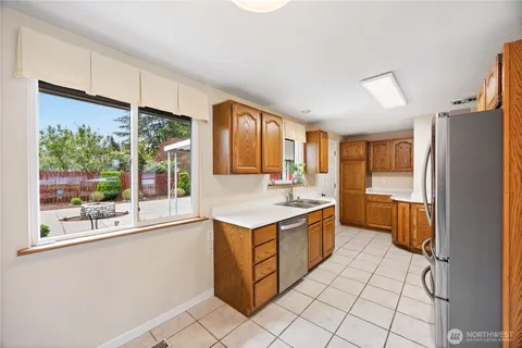 a kitchen with stainless steel appliances granite countertop a stove a sink and a refrigerator