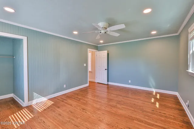 a view of an empty room with wooden floor