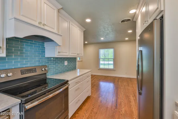 a kitchen with wooden floors and appliances