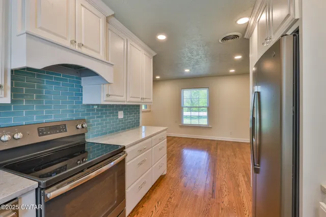 a kitchen with wooden floors and appliances