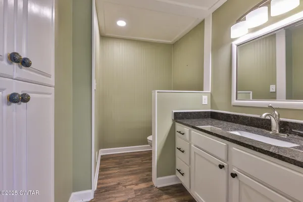 a bathroom with a granite countertop sink a mirror and a shower