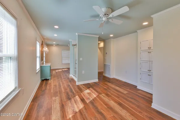 a view of a big room with wooden floor and a window