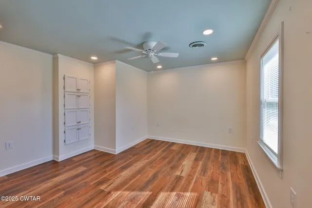 wooden floor in an empty room with a window